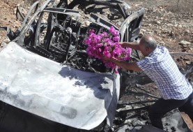 فلسطيني يضع الزهور على السيارة التى استشهد فيها أطفاله