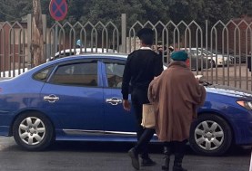 شرطي يساعد امرأة مسنة في عبور الطريق
